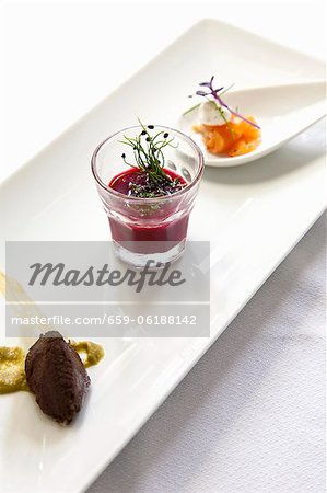 An appetizer platter with olive paste, beetroot soup and smoked salmon