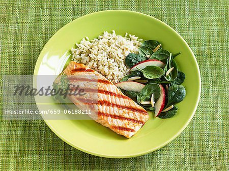 Grilled Salmon with Rice and Spinach Salad with Sliced Radish and Almonds; On a Green Plate Grilled Salmon with Rice and Spinach Salad with Sliced Radish and Almonds; On a Green Plate