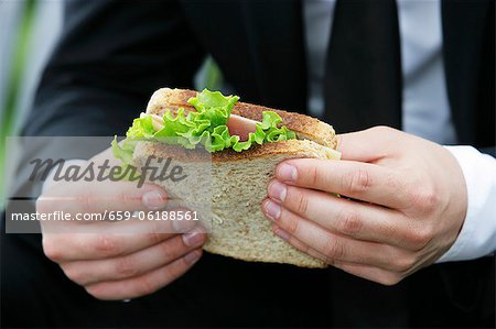 A man holding a ham and cheese sandwich