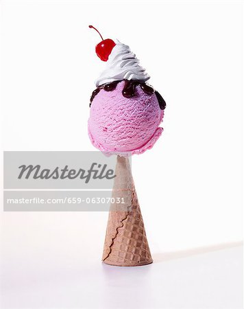Scoop of Raspberry Ice Cream with Chocolate Sauce, Whipped Cream and a Cherry on an Upside Down Cone; White Background