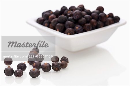 Juniper berries in a bowl and next to it