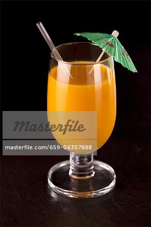 An orange smoothie with a cocktail umbrella