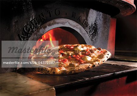 Pizza In Front of a Wood Fired Oven
