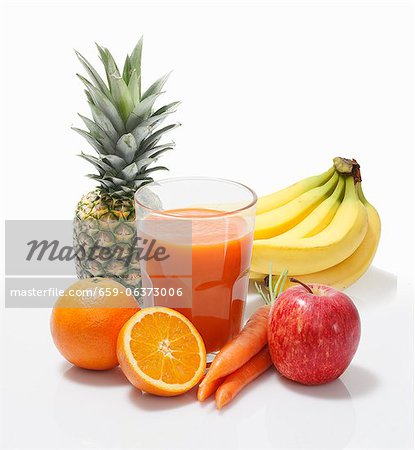 Multi-vitamin juice surrounded by whole fruits