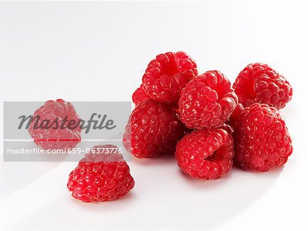 Several raspberries against white background