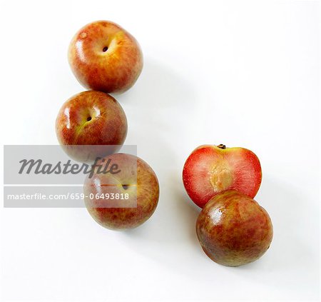 Fresh Whole Loquat Fruit; One Halved; White Background