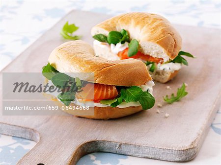 Cream cheese, bittercress and smoked salmon bagel on a chopping board Cream cheese, bittercress and smoked salmon bagel on a chopping board