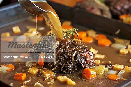 Roast venison with root vegetables in a pan