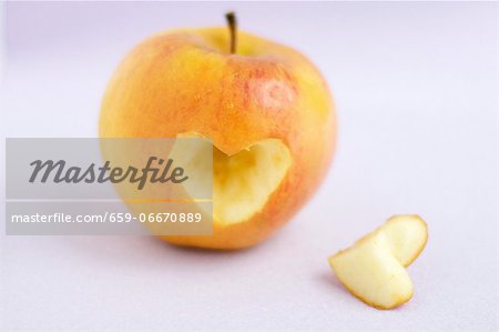 An apple with a heart-shape cut out of it