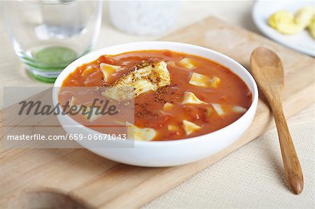 Bowl of Tomato Artichoke Soup; Wooden Spoon