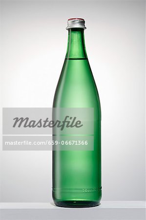 A green bottle filled with water A green bottle filled with water
