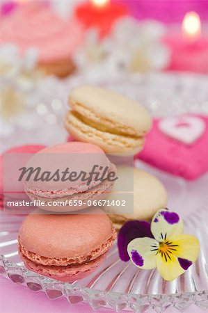 Vanilla, strawberry and raspberry macaroons on a glass plate with a pansy Vanilla, strawberry and raspberry macaroons on a glass plate with a pansy