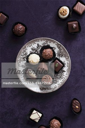 An assortment of filled chocolates, some on a plate