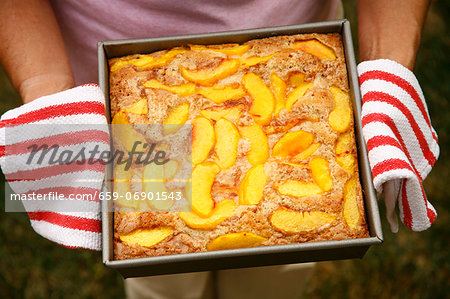 Woman Holding Fresh From the Oven Peach Cobbler