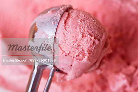 A scoop of home-made strawberry ice cream in an ice-cream scoop