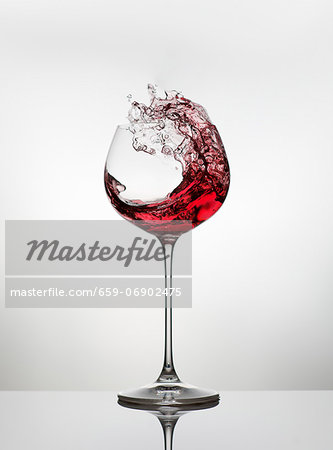 Red wine spattering out of a glass Red wine spattering out of a glass