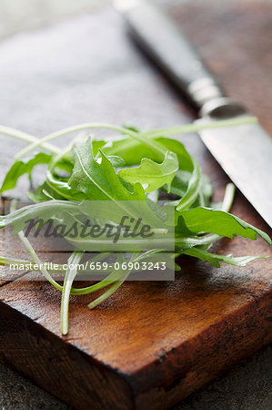 Rocket and a knife on a wet wooden board Rocket and a knife on a wet wooden board