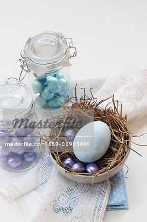 Mini chocolate eggs in preserving jars and a painted egg in a nest for Easter Mini chocolate eggs in preserving jars and a painted egg in a nest for Easter