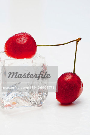 Red cherries with an ice cube Red cherries with an ice cube