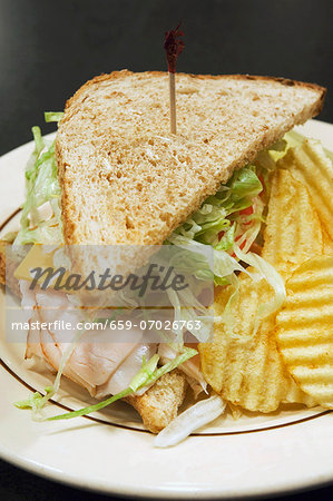 Turkey sandwich with cheese and salad and crisps Turkey sandwich with cheese and salad and crisps