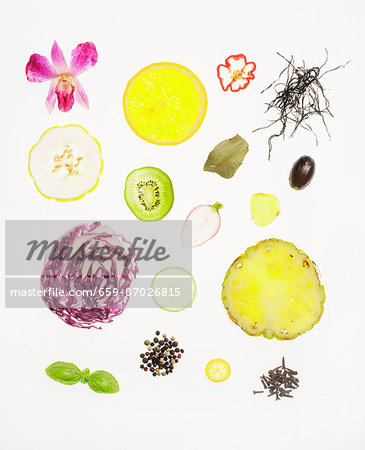 Assorted Slices of Vegetables, Fruit, Herbs and Seeds on a White Background