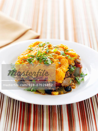 A Serving of Shepherd's Pie Topped with Sweet Potato on a White Plate