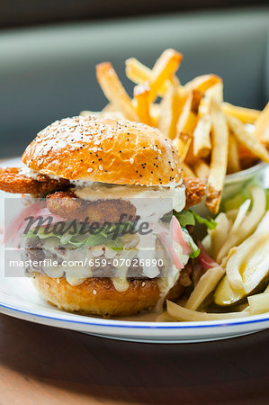 Cheeseburger Topped with Fried Oysters and Mayo Sauce; Served with Pickle and French Fries