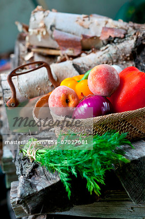 Fresh Veggies and Fruit in a Basket; Bunch of Fresh Dill; On a Woodpile