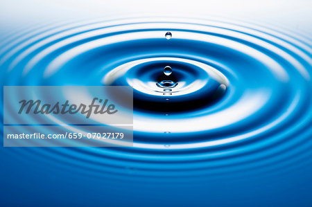 A drop falling into water and forming circles on the water surface