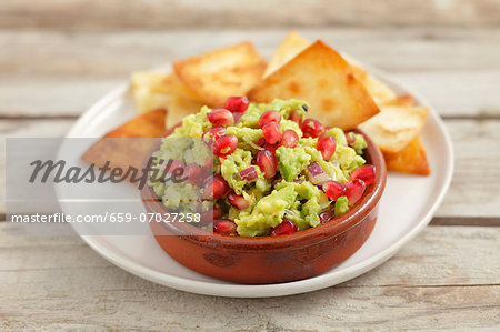 Guacamole with pomegranate seeds and tortilla chips