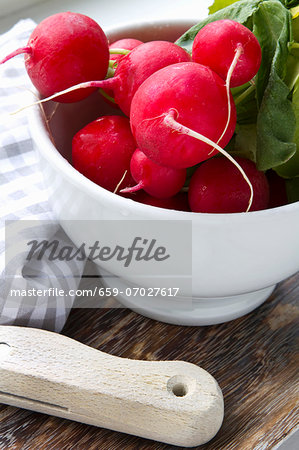 Fresh radishes in a white bowl