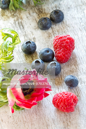 Fresh berries next to a pink flower