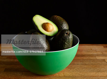 Avocados in a Green Bowl; One Halved