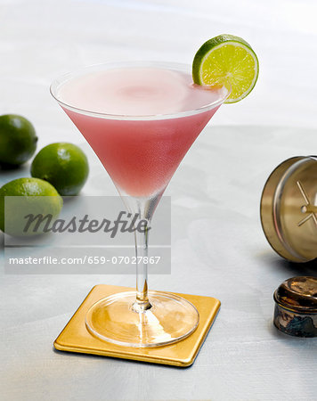 A Cosmopolitan on a Coaster with a Lime Slice Garnish