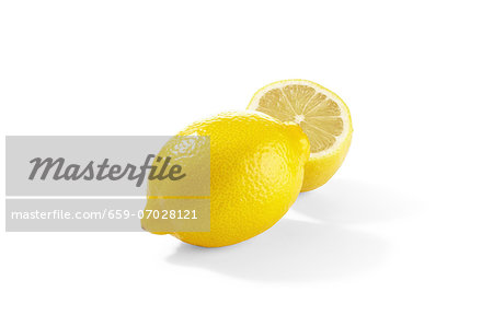A lemon and a lemon half on a white surface