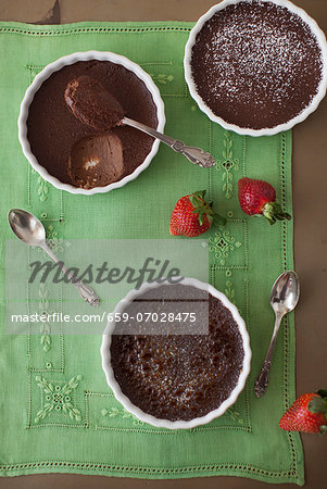 Three Chocolate Creme Brulees with Strawberries on Green Linen