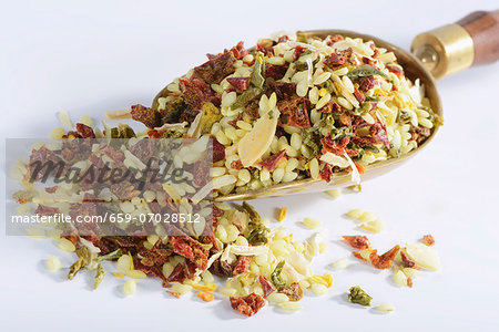 Vialone Nano risotto rice with dried vegetables and flavourings on a brass scoop Vialone Nano risotto rice with dried vegetables and flavourings on a brass scoop
