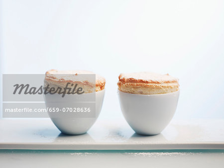 Two passion fruit soufflés against a white background