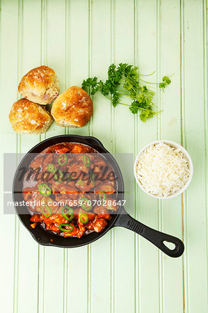 Spicy turkey goulash in the pan with rice and bread rolls Spicy turkey goulash in the pan with rice and bread rolls