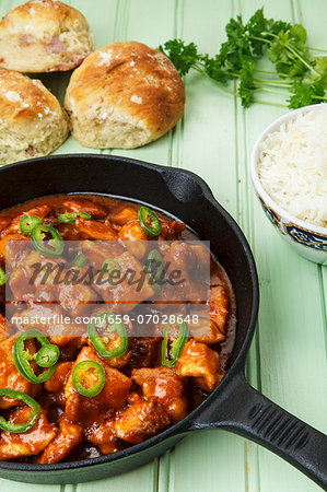 Spicy turkey goulash in a pan, with rice and bread rolls Spicy turkey goulash in a pan, with rice and bread rolls