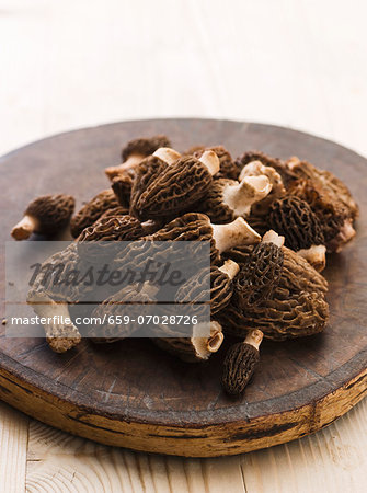 Fresh morels on a round wooden board