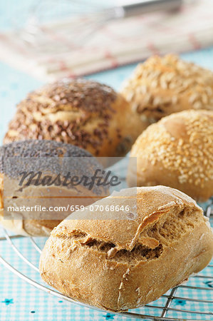 Assorted freshly baked rolls on a cooling rack