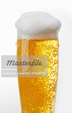 A glass of light beer with beer foam