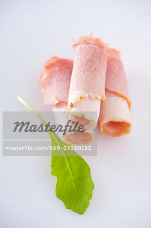 Rolled ham slices and a rocket leaf