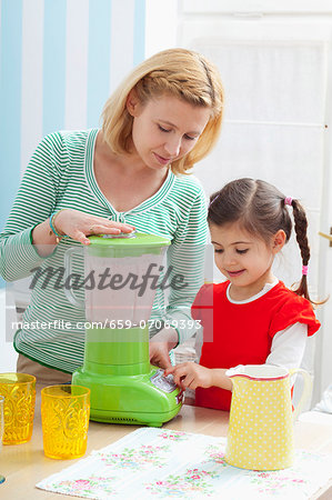 A mother and daughter preparing a strawberry milkshake A mother and daughter preparing a strawberry milkshake