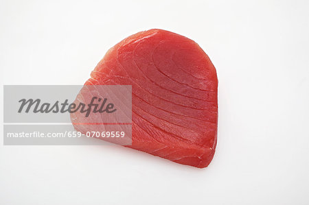 Raw tuna steak on a white surface