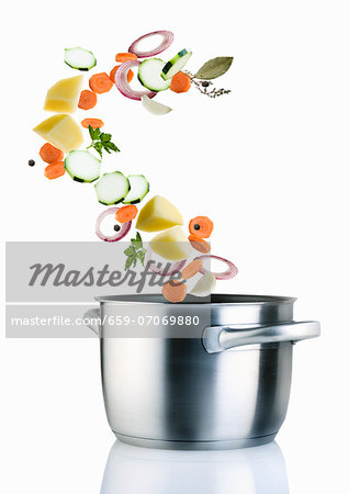 Ingredients for vegetable soup falling into a saucepan Ingredients for vegetable soup falling into a saucepan