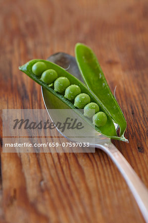 Peas Inside an Open Pea Pod on a Spoon