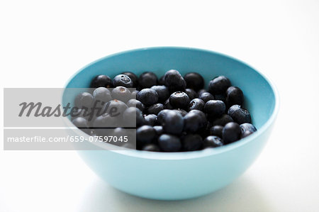 A bowl of blueberries on a white background A bowl of blueberries on a white background