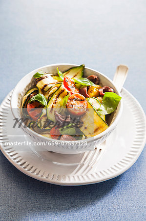 Grilled zucchini with tomatoes, olives and basil